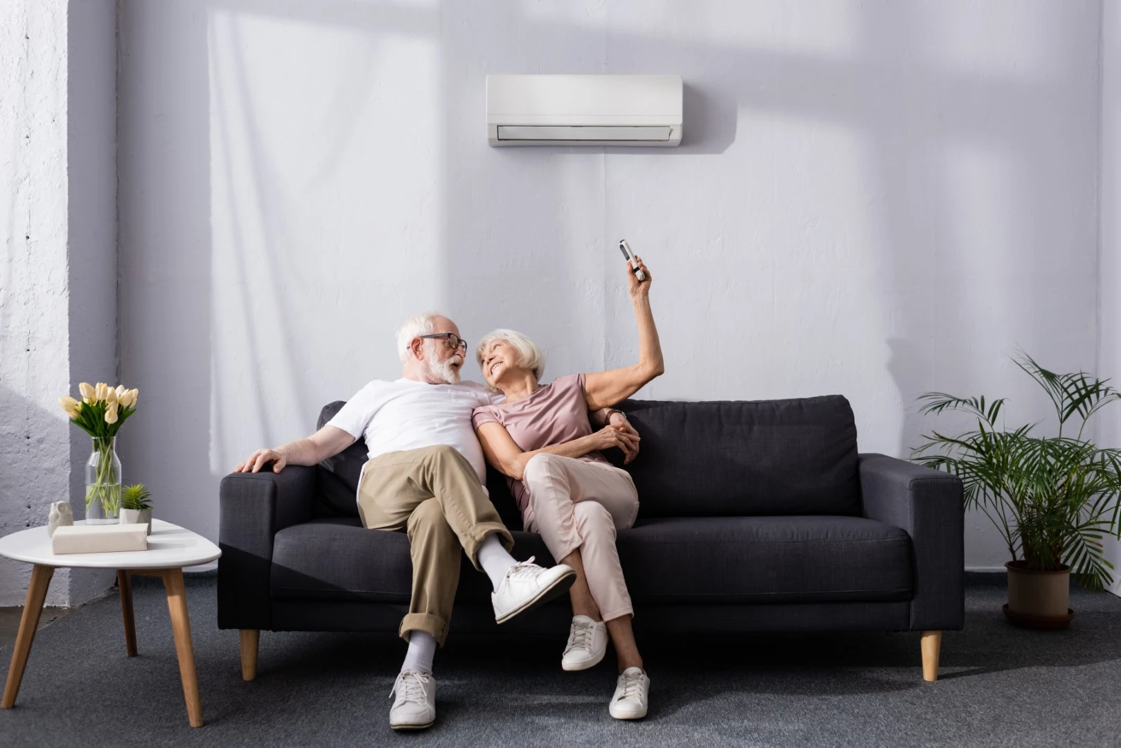 Older couple on the bed with an split a/c system on the wall supplied by GOLDEN AGE HOUSING PRODUCTS
